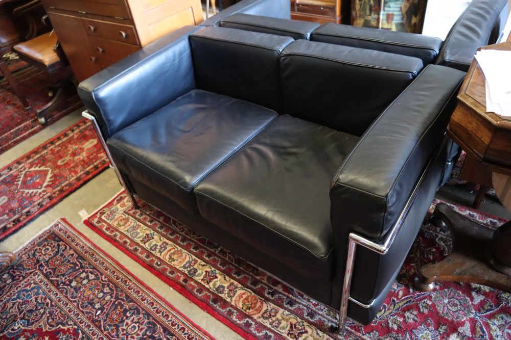 A pair of Corbusier style black leather and chrome two seater sofas, length 130cm, depth 66cm, height 68cm